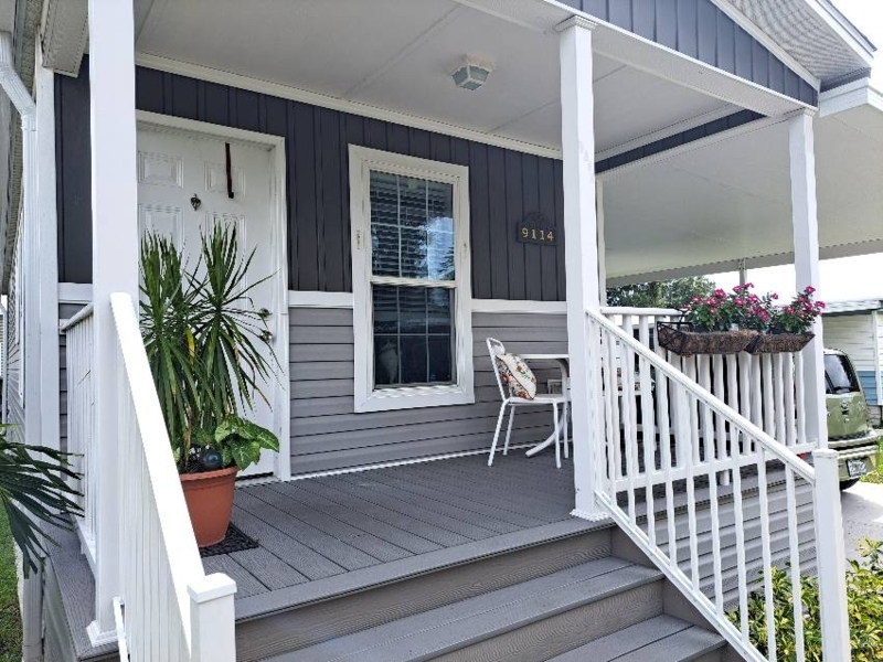 Modern Two-Tone Gray Porch Entryway with White Railing and Planters