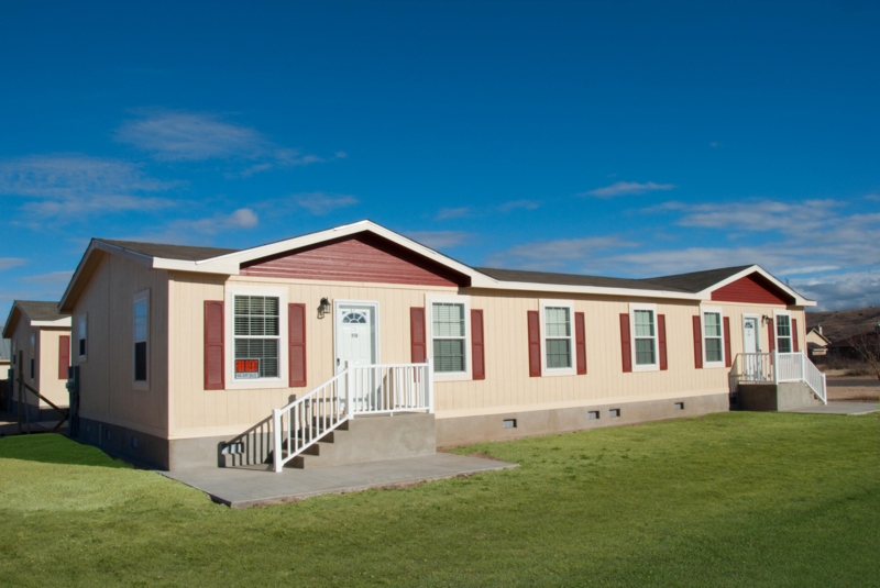 Modular Duplex Exterior with Maroon Gables and Tan Siding, White Railings