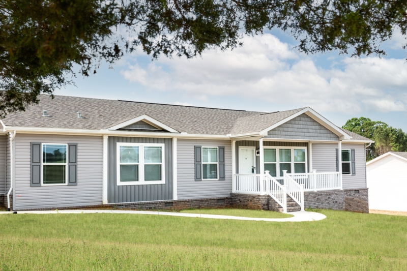 Modular Home Exterior: Gray Siding, Brick Foundation & Curved Path