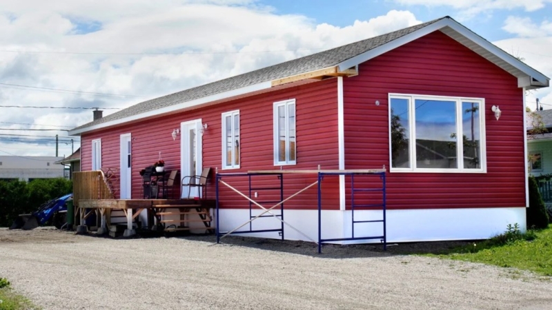 Modular Home Exterior Red Siding Large Picture Window White Skirting