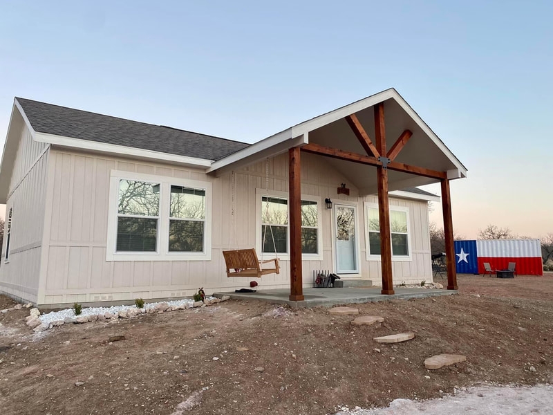 Modular Home Porch with Natural Wood Trusses and Rustic Wooden Swing