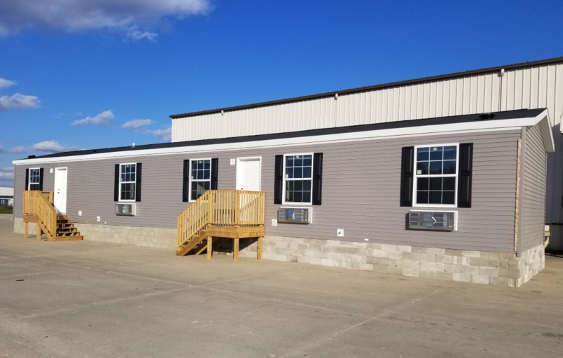 Modular Home with Concrete Skirting, Wood Porches, and Grey Vinyl Siding