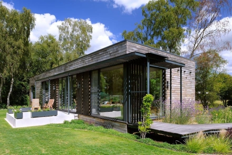 Modular Home with Weathered Wood Siding and Integrated Slatted Shading.