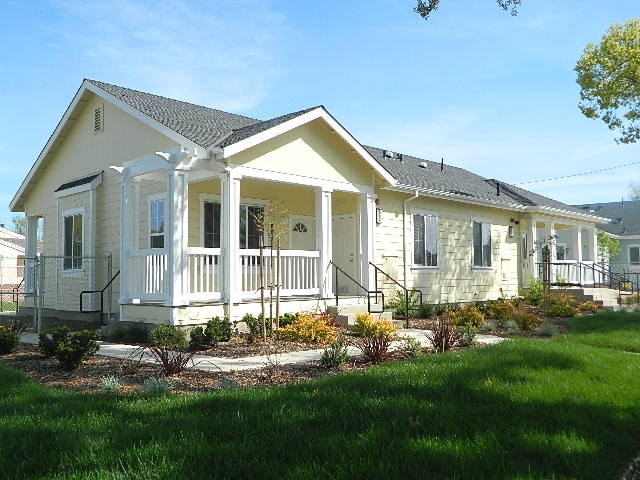 Multi Family Building Exterior Pale Yellow Siding, White Porch Railing