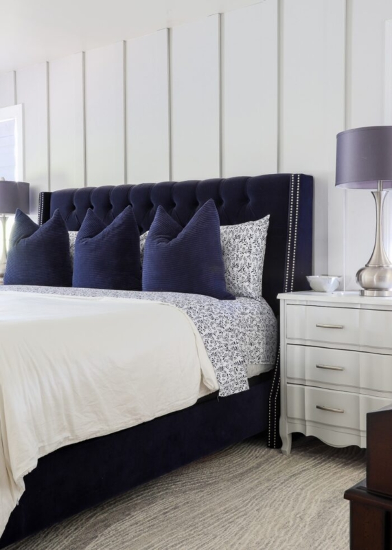 Navy Tufted Headboard with Nailhead Trim against White Board and Batten