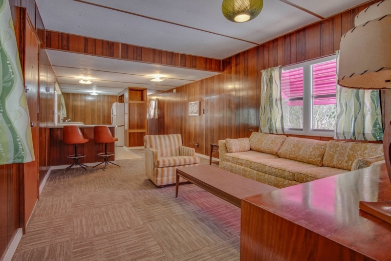 Orange Swivel Stools and Vertical Wood Paneling in Mid-Century Home