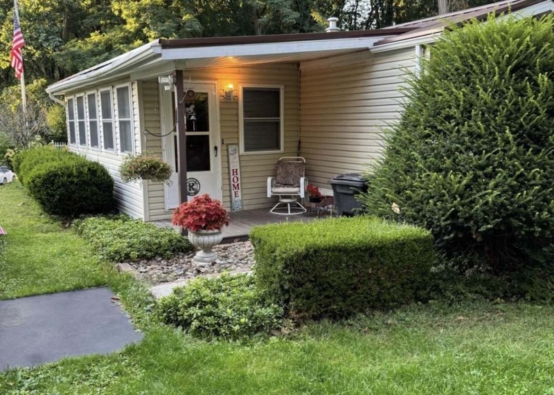 Porch Exterior Traditional Cottage Beige Siding with Manicured Shrubs