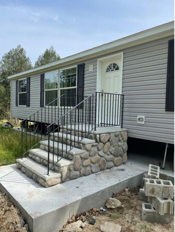 Precast Stairs, River Stone Veneer with Integrated Black Railing.