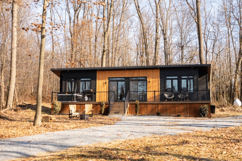 Prefab Cabin featuring Contrasting Siding and an Expansive Deck.