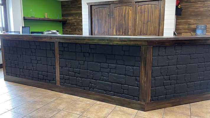 Reception Desk with Black Stone Veneer and Dark Wood Trim.