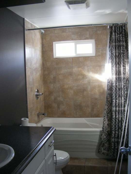 Residential Bathroom with High Privacy Window, Tan Tile Alcove, and Curtain