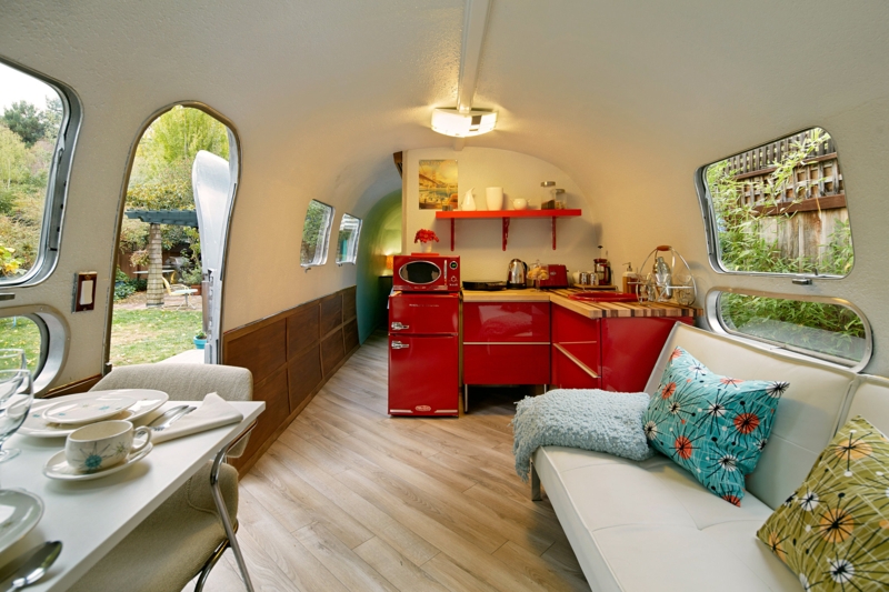 Retro Trailer Interior with Red Appliances and Starburst Pillows