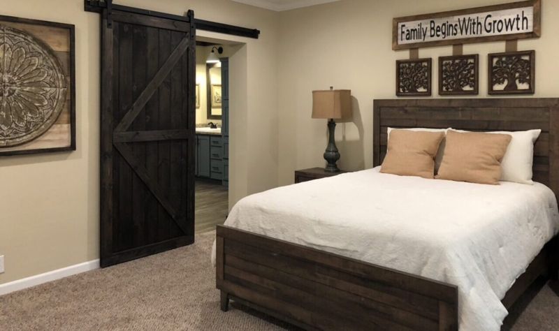 Rustic Bedroom with Barn Door: Dark Wood Finishes and Beige Walls