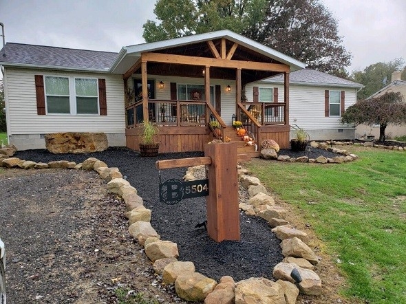 Rustic Gabled Wood Porch with Stone Bordered Landscaping