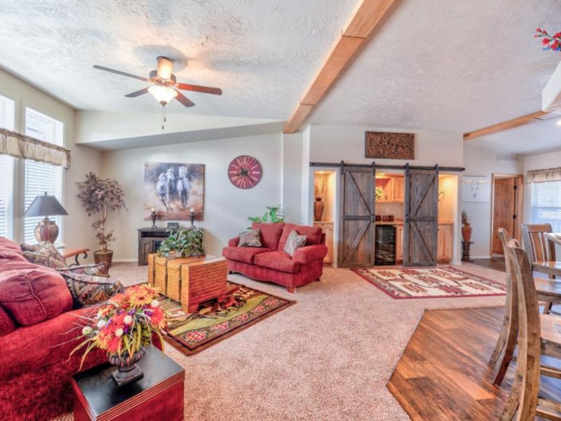 Rustic Living Room with Barn Doors, Red Sofas, and Sloped Ceiling Beam