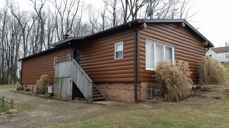 Rustic Log-Look Siding with Brick Foundation Skirting
