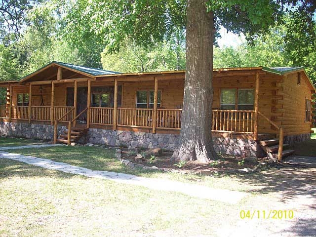 Rustic Log-Sided Mobile Home with a Full-Length Porch