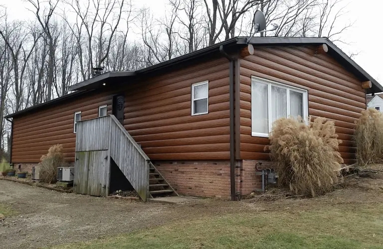 Rustic Mobile Home: Log Profile Siding, Brick Foundation