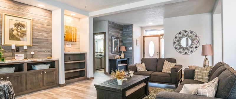 Rustic Wood Paneled Living Room with Dark Gray Sofas and Plaid Accents