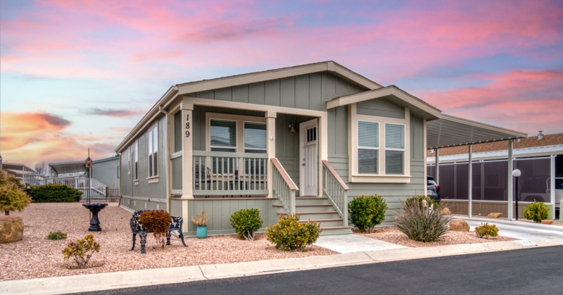 Sage Green Mobile Home with Attached Carport and Desert Landscaping