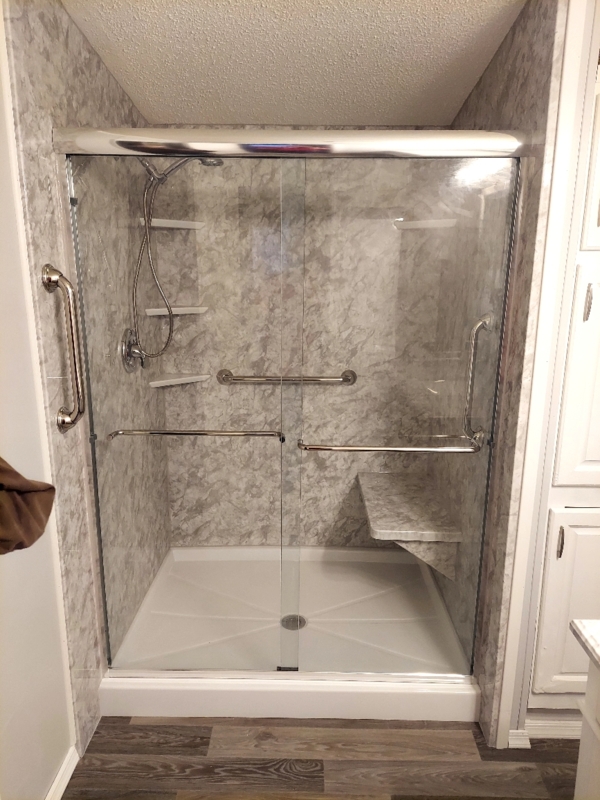 Shower Enclosure with Marbled Wall Panels and Built In Bench Seat.