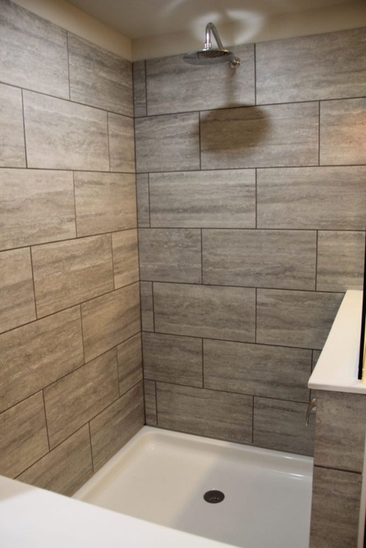 Shower Stall Upgrade featuring Rain Shower Head and Gray Stone Tiles