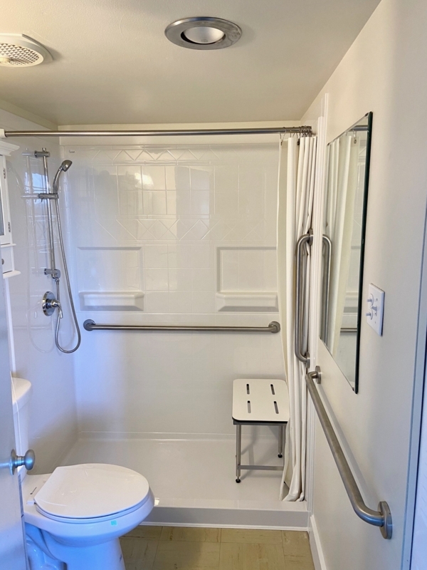 Shower Stall with Integrated Grab Bars and Folding Seat.