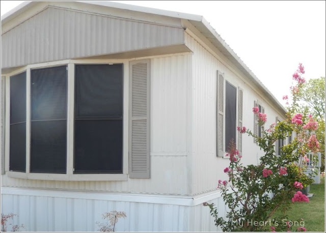 Simple Mobile Home Exterior: Off-White Siding with Grey Shutters