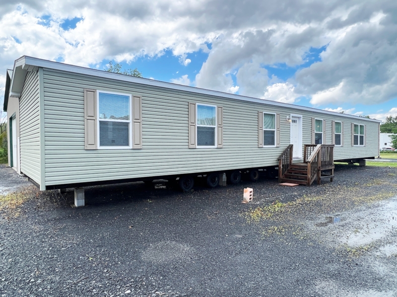 Single-Wide Mobile Home with Sage Green Exterior and Tan Shutters