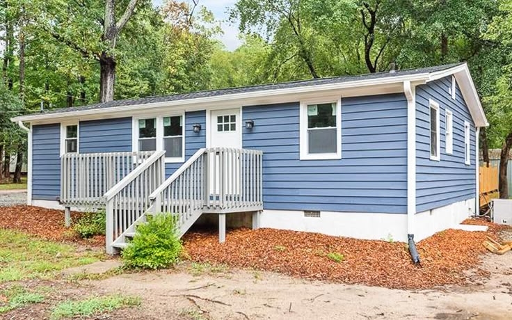 Slate Blue Mobile Home Exterior with White Skirting and Wood Porch