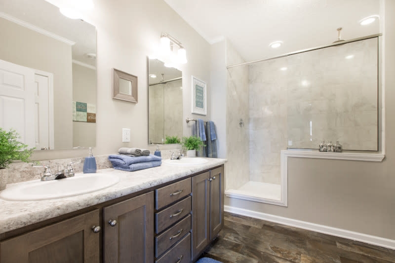 Spacious Bathroom: Wood-Toned Double Vanity and Glass Partition Shower