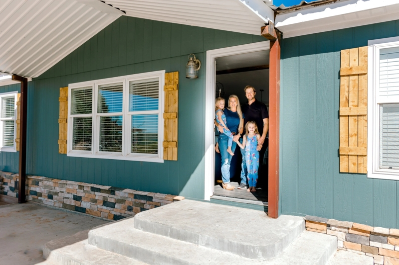 Teal Mobile Home Exterior with Natural Wood Shutters and Stone Skirting