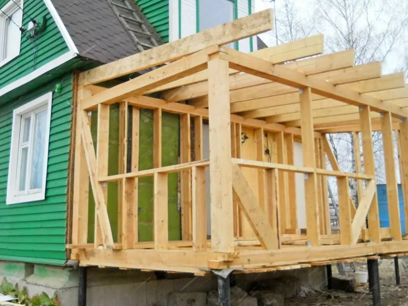 Timber Frame Room Extension: Structural Timber with Green Siding Contrast