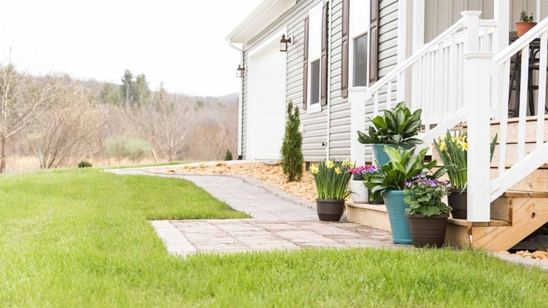 Traditional Landscaping with Curved Paver Path and Tiered Planters