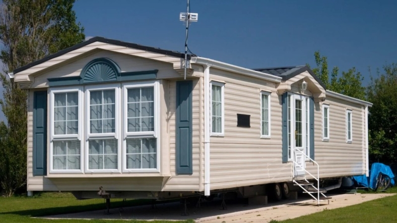 Traditional Mobile Home: Teal Shutters on Cream Siding with Bay Window
