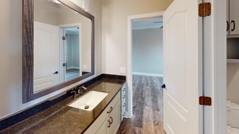 Transitional Bathroom Vanity with Dark Stone Countertop and Framed Mirror