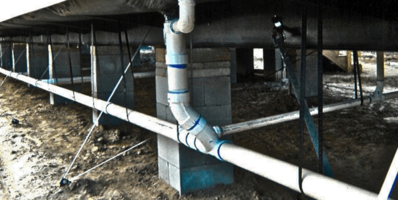Under-Home PVC Plumbing System with Support Straps in Crawl Space