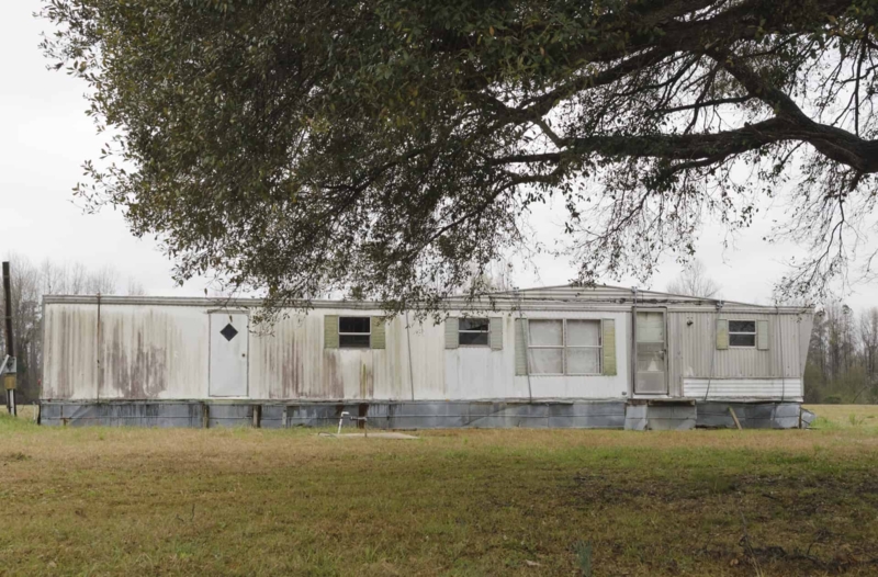Vintage Mobile Home with Weathered Siding and Diamond Window Detail