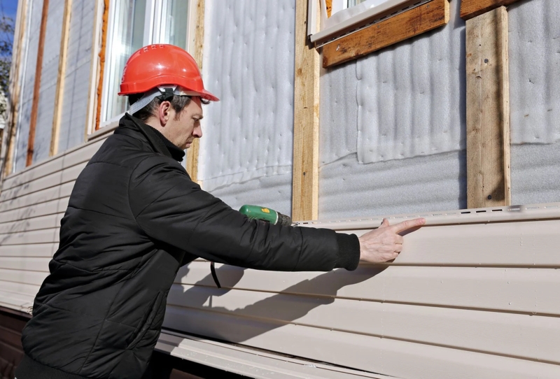 Vinyl Siding Installation: Beige Interlocking Horizontal Slats.