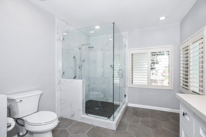 Walk-In Shower with Contrasting Hexagonal Tiles and Frameless Glass