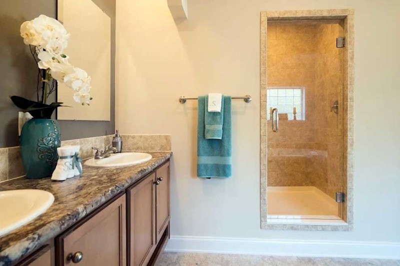 Walk In Shower with Stone Tiled Walls and Teal Accent Decor.