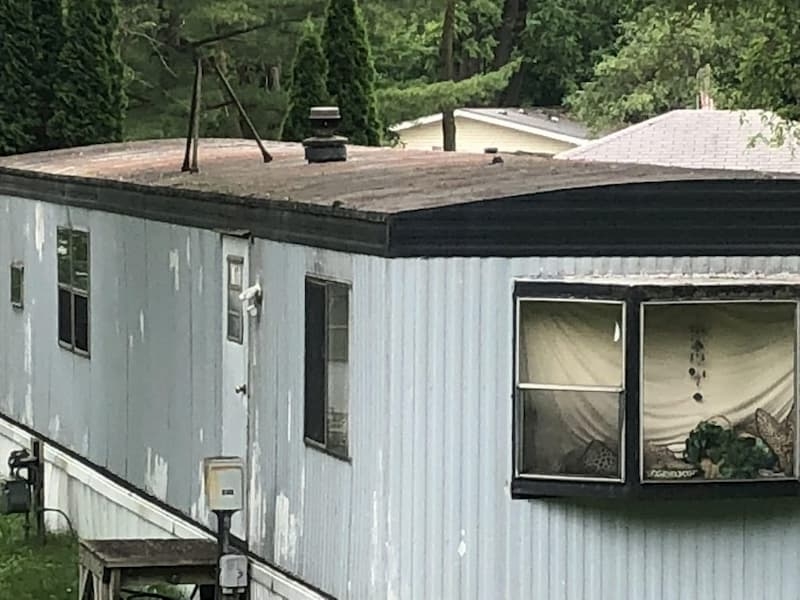 Weathered Mobile Home Flat Roof with Bay Window Feature