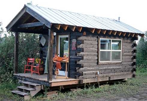 Western Style Log Cabin with Red Porch Seating and Saddle