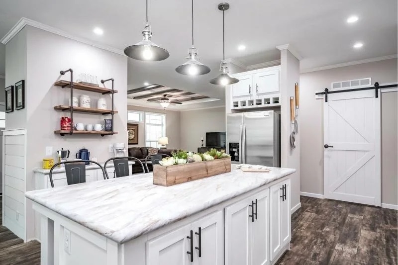 White Kitchen with Sliding Barn Door and Marble Look Laminate Island