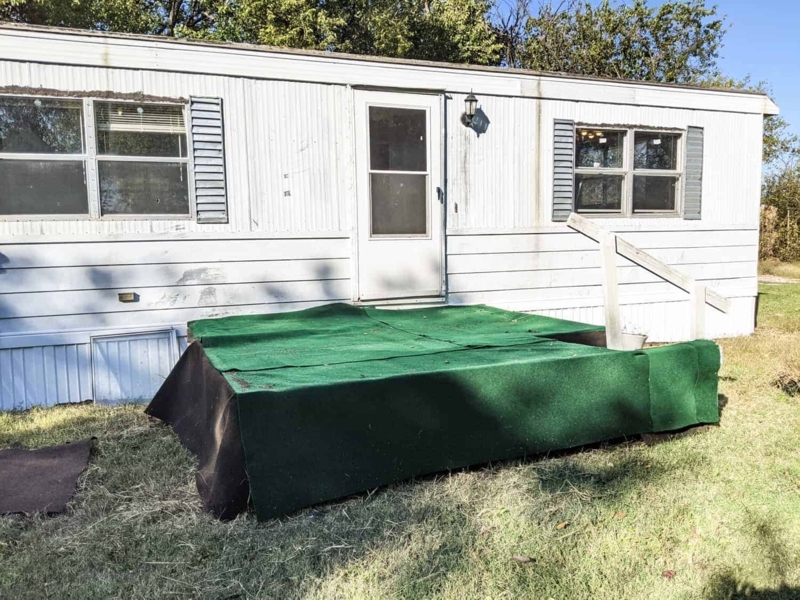 White Mobile Home Exterior with Green Turf Landing and Grey Shutters