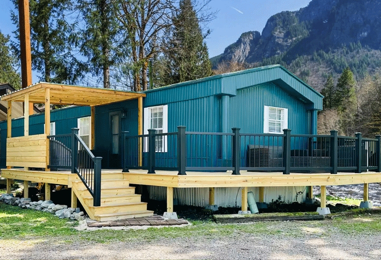 Wrap Around Deck with Teal Siding and Modern Black Railing