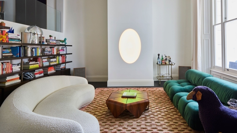 Artistic Loft Living Room: Curved White Sofa & Emerald Green Seating