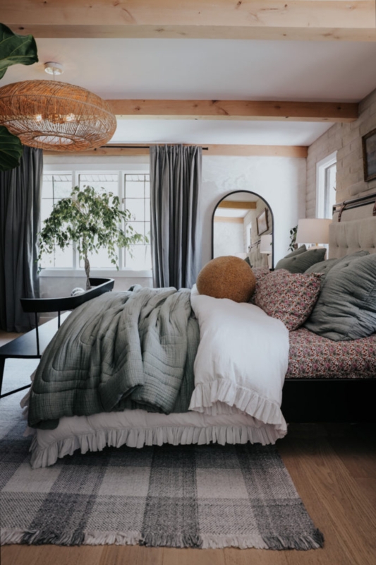 Bed with Ruffled White Linens, Sage Green Quilt and Exposed Wood Beams