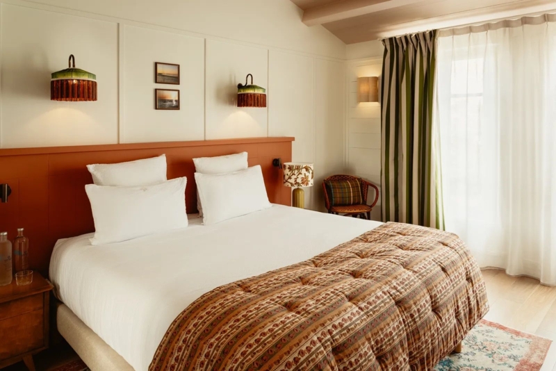 Bed with Terracotta Headboard, Pleated Sconces and Striped Curtains