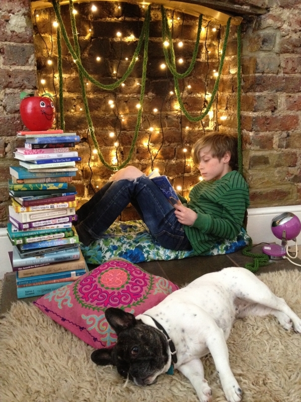 Bohemian Reading Nook inside Fireplace with Yarn Garland & Fairy Lights.